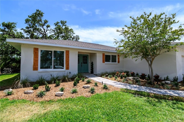 ranch-style home with a front yard and stucco siding