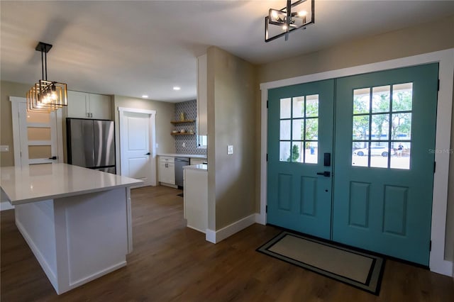 doorway to outside with an inviting chandelier, baseboards, recessed lighting, and dark wood-style floors