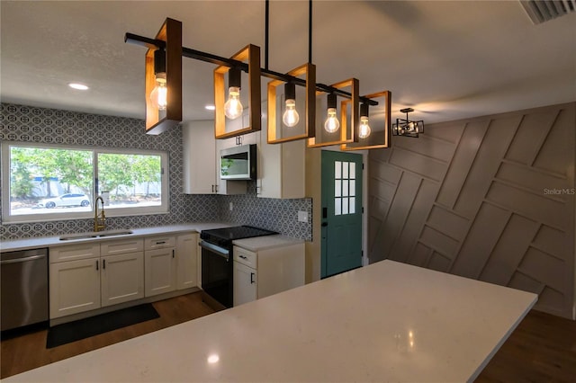 kitchen with white cabinets, stainless steel appliances, dark wood-style floors, and a sink