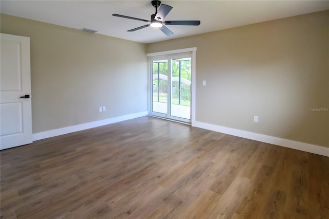 empty room with ceiling fan, baseboards, visible vents, and wood finished floors