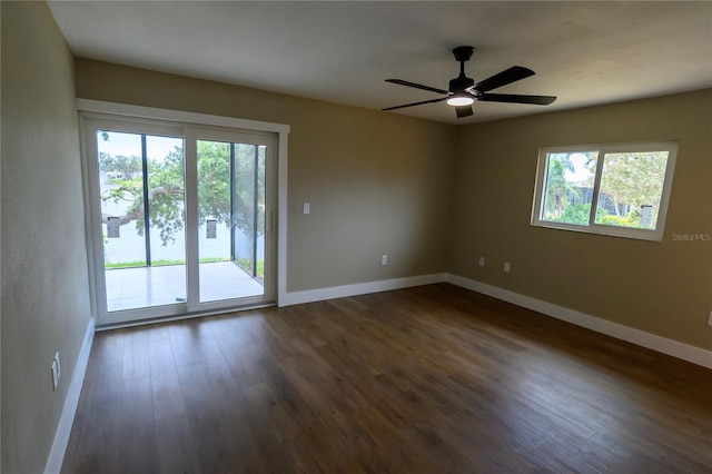 spare room with a ceiling fan, baseboards, dark wood finished floors, and a healthy amount of sunlight