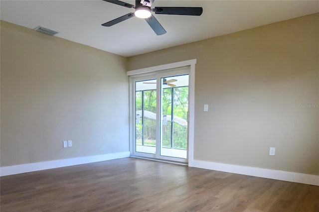 unfurnished room with baseboards, wood finished floors, and visible vents