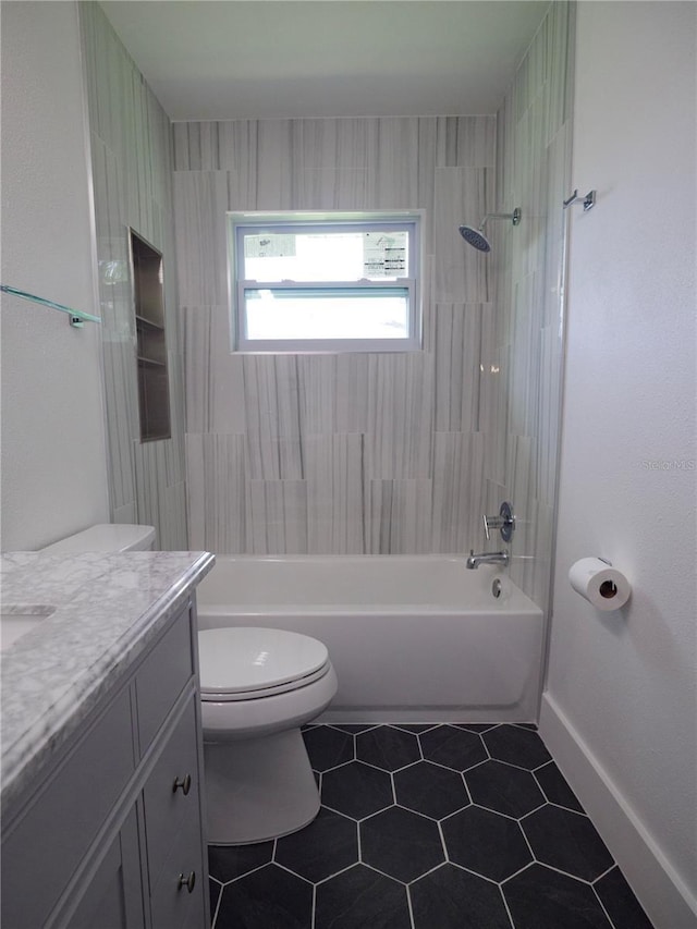 bathroom featuring tile patterned floors, baseboards, vanity, toilet, and  shower combination