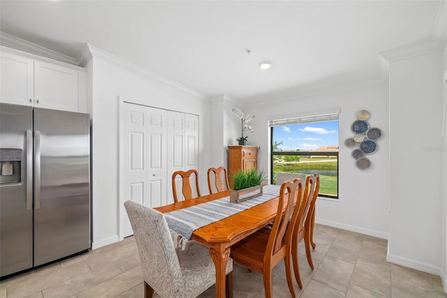 dining area featuring crown molding, baseboards, and light tile patterned flooring