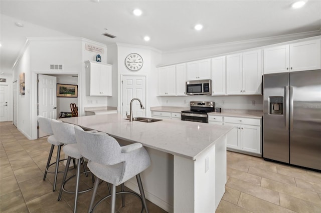 kitchen with crown molding, a sink, stainless steel appliances, white cabinetry, and visible vents