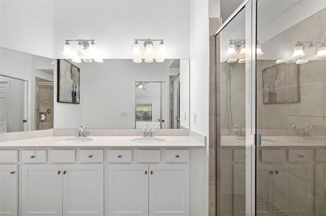 full bathroom with double vanity, ceiling fan, a shower stall, and a sink