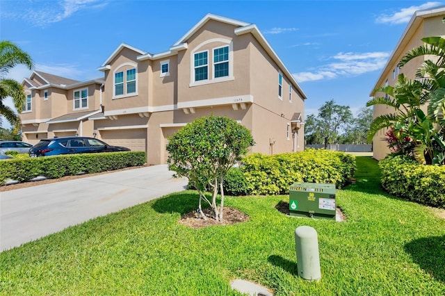 view of front of property featuring concrete driveway, an attached garage, a front lawn, and stucco siding