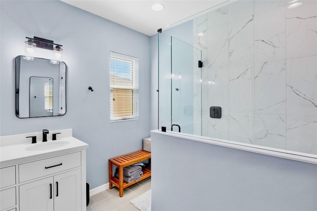bathroom with baseboards, a marble finish shower, tile patterned flooring, and vanity
