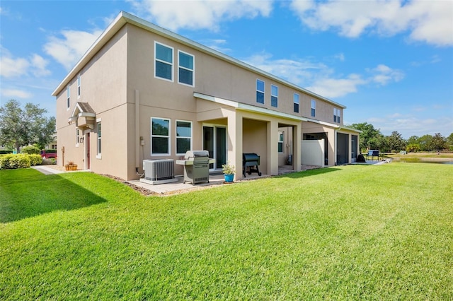 back of house featuring a lawn, stucco siding, and central AC