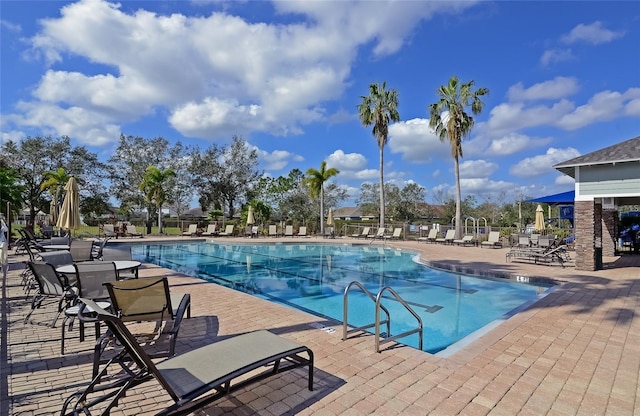 community pool with a patio and fence