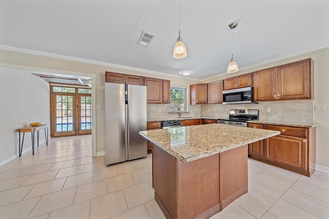 kitchen featuring visible vents, appliances with stainless steel finishes, tasteful backsplash, brown cabinets, and ornamental molding