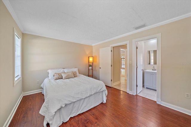 bedroom with visible vents, ornamental molding, wood finished floors, and multiple windows