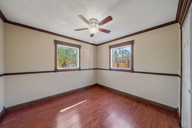 empty room featuring baseboards, a ceiling fan, dark wood finished floors, and a healthy amount of sunlight