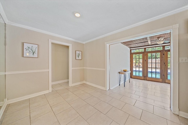 spare room with light tile patterned floors, baseboards, ornamental molding, and ceiling fan