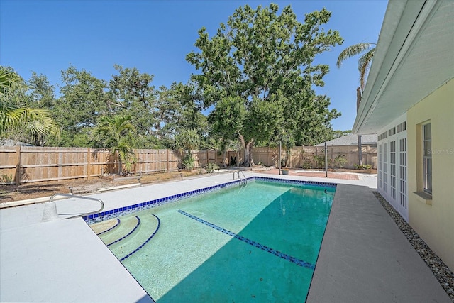 view of swimming pool with a fenced in pool, a fenced backyard, and a patio area