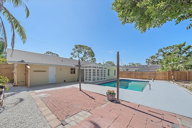 view of swimming pool featuring french doors, a fenced in pool, a patio, and a fenced backyard
