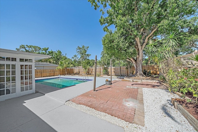 view of pool with french doors, a fenced in pool, a fenced backyard, and a patio area