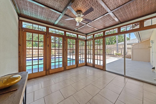 unfurnished sunroom with an ornate ceiling, a textured wall, tile patterned floors, and a healthy amount of sunlight