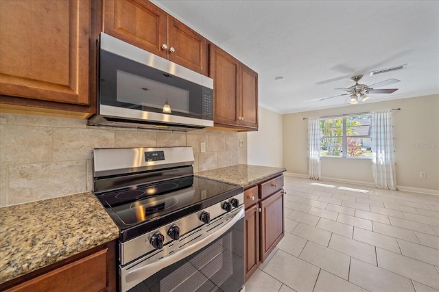 kitchen with appliances with stainless steel finishes, brown cabinetry, baseboards, tasteful backsplash, and ornamental molding