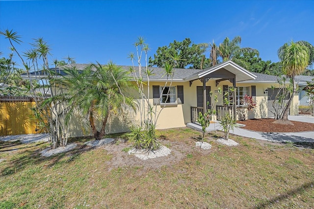 ranch-style home featuring fence and stucco siding