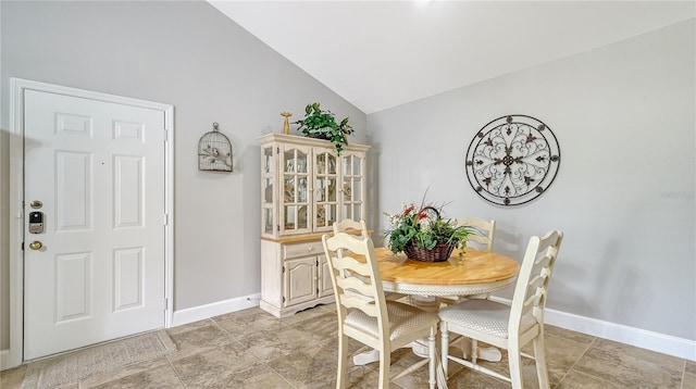 dining room featuring baseboards and vaulted ceiling