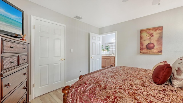 bedroom with light wood-style floors, visible vents, and baseboards