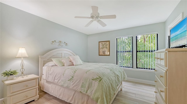 bedroom with baseboards, light wood finished floors, and ceiling fan