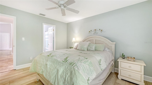 bedroom with light wood finished floors, baseboards, ceiling fan, and visible vents