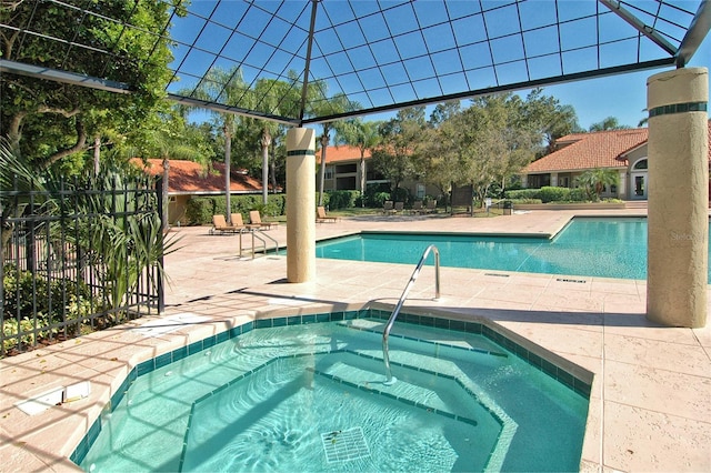 pool with a patio area and a hot tub