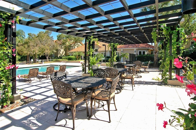 view of patio / terrace with a community pool, fence, a pergola, and outdoor dining area