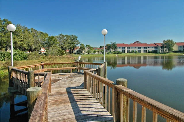view of dock with a water view and a residential view