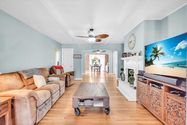 5012 Eastchester Dr, Sarasota, FL 34234 - living area with arched walkways, ceiling fan, a fireplace with raised hearth, and light wood finished floors