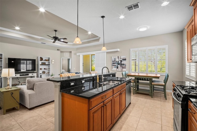 kitchen with visible vents, plenty of natural light, brown cabinets, a sink, and appliances with stainless steel finishes