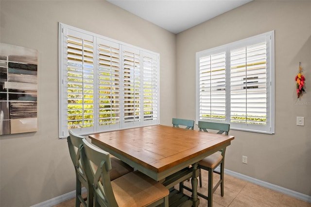 dining space featuring baseboards, tile patterned flooring, and a wealth of natural light