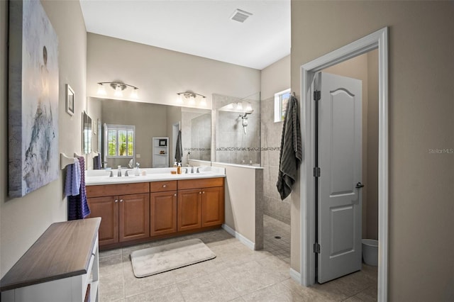 full bath featuring tile patterned flooring, double vanity, visible vents, walk in shower, and a sink