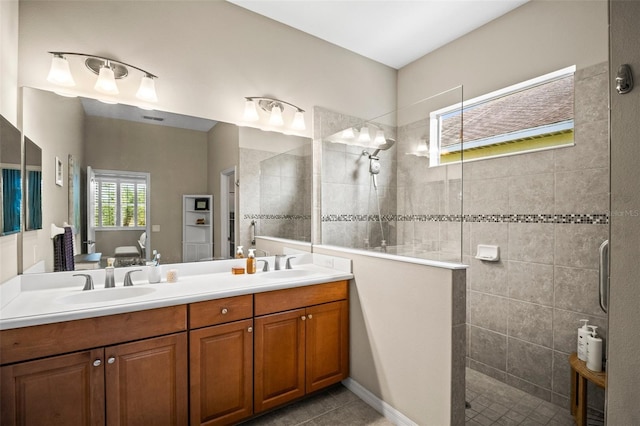 bathroom featuring double vanity, walk in shower, a sink, and tile patterned flooring
