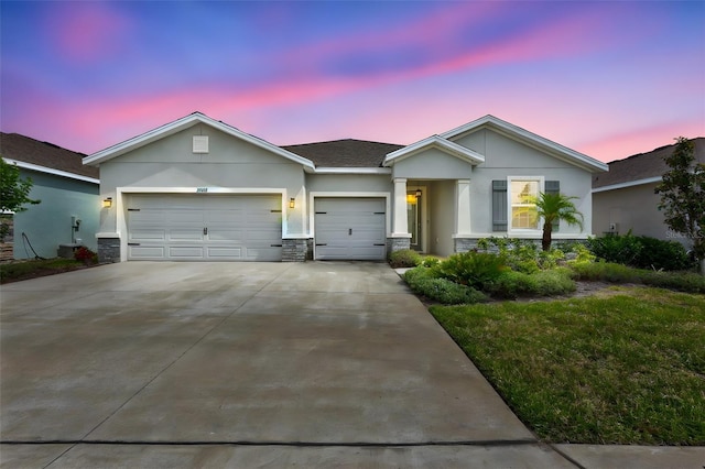single story home featuring concrete driveway, an attached garage, stucco siding, and stone siding