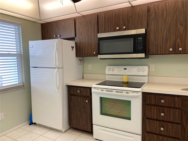 kitchen featuring white appliances, light tile patterned floors, light countertops, and plenty of natural light