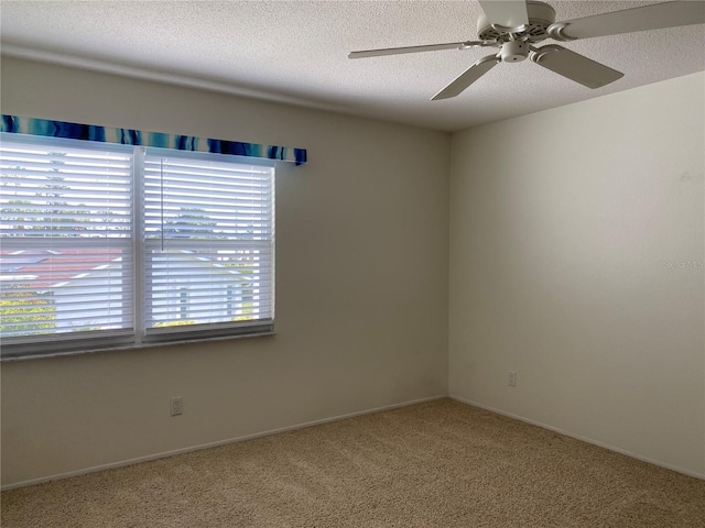 spare room featuring carpet flooring, a ceiling fan, a textured ceiling, and baseboards