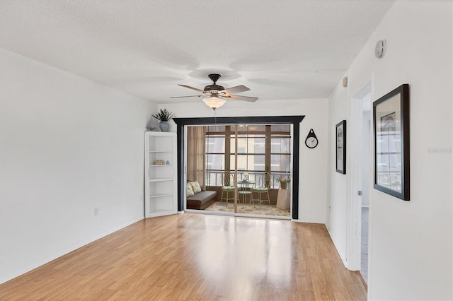 2280 Stickney Point Rd Unit 420, Sarasota, FL 34231 - empty room featuring baseboards, a textured ceiling, ceiling fan, and wood finished floors