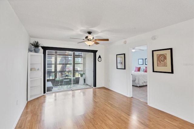 2280 Stickney Point Rd Unit 420, Sarasota, FL 34231 - spare room with light wood-type flooring, a ceiling fan, a textured ceiling, and baseboards