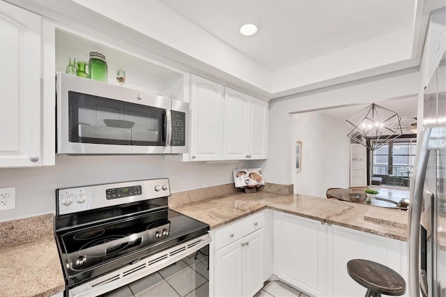 2280 Stickney Point Rd Unit 420, Sarasota, FL 34231 - kitchen with an inviting chandelier, appliances with stainless steel finishes, light tile patterned flooring, and white cabinets