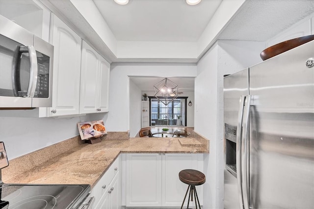 2280 Stickney Point Rd Unit 420, Sarasota, FL 34231 - kitchen with light countertops, white cabinetry, a notable chandelier, and appliances with stainless steel finishes