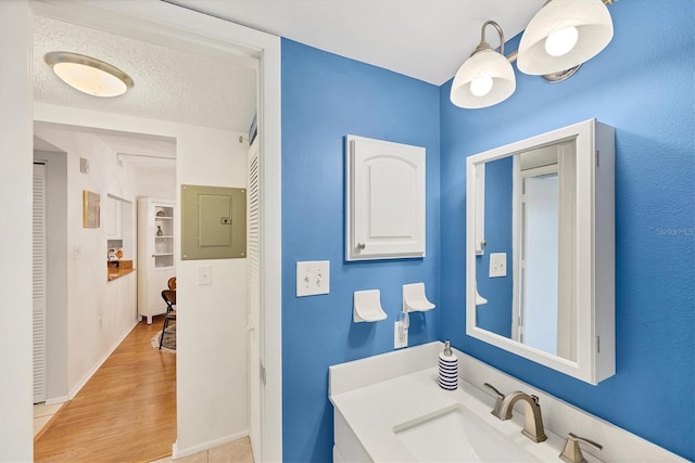 2280 Stickney Point Rd Unit 420, Sarasota, FL 34231 - bathroom with a sink, baseboards, electric panel, and wood finished floors