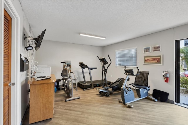 2280 Stickney Point Rd Unit 420, Sarasota, FL 34231 - workout area featuring a textured ceiling and wood finished floors