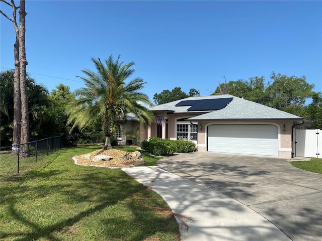 652 N Elm St, Englewood, FL 34223 - single story home with an attached garage, concrete driveway, solar panels, stucco siding, and a gate