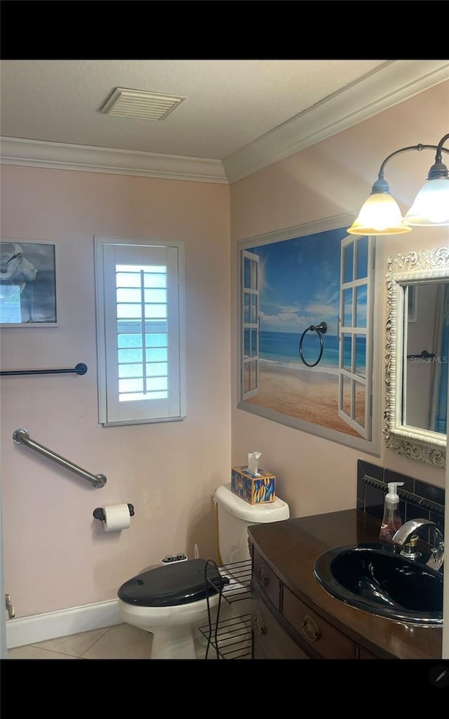652 N Elm St, Englewood, FL 34223 - bathroom featuring ornamental molding, toilet, baseboards, vanity, and tile patterned flooring
