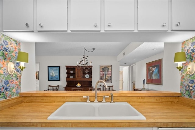 kitchen featuring white cabinets, light countertops, visible vents, and a sink