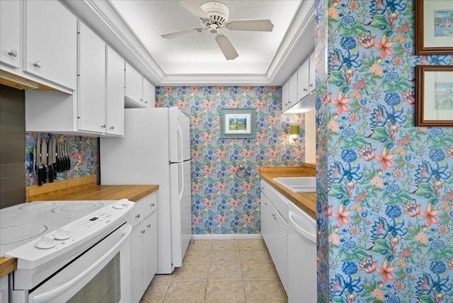 kitchen featuring white appliances, white cabinetry, a ceiling fan, baseboards, and wallpapered walls