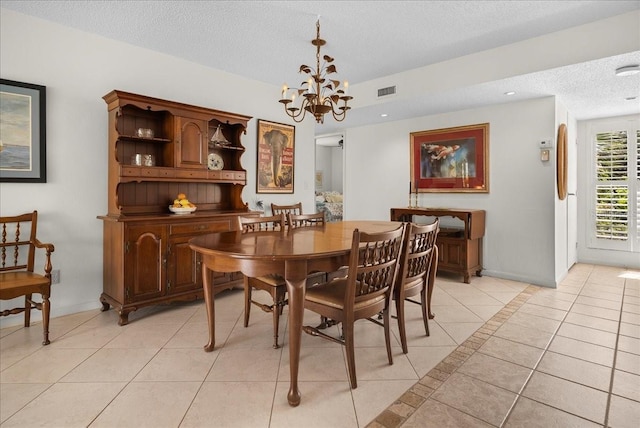 dining space featuring light tile patterned floors, a chandelier, visible vents, and a textured ceiling